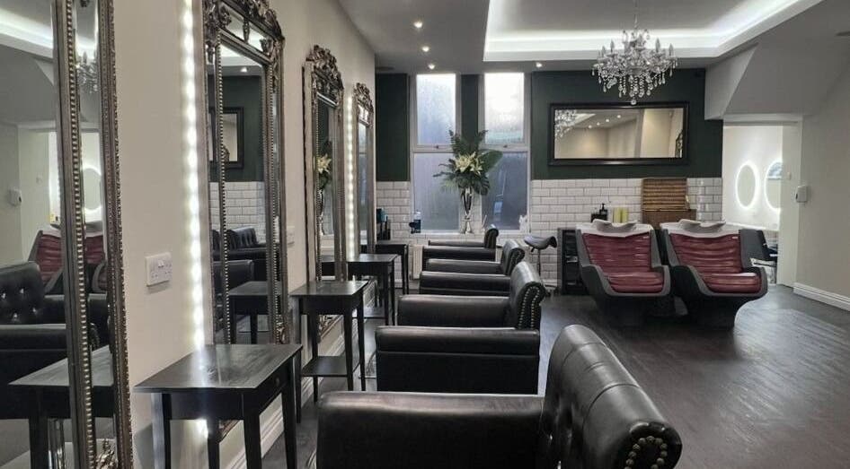 Chic interior of Newcastle Hair Company in Newcastle upon Tyne, showcasing plush chairs and ornate mirrors.