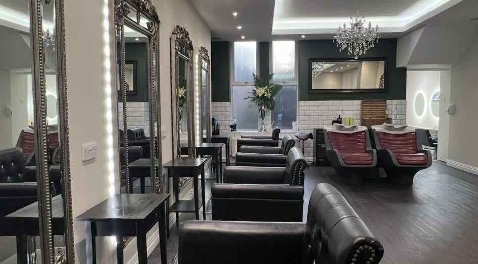 Chic interior of Newcastle Hair Company in Newcastle upon Tyne, showcasing plush chairs and ornate mirrors.