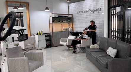 Interior de BEYOUTIFUL en Quito, Pichincha, EC. Cliente recibiendo tratamiento capilar en salón moderno.
