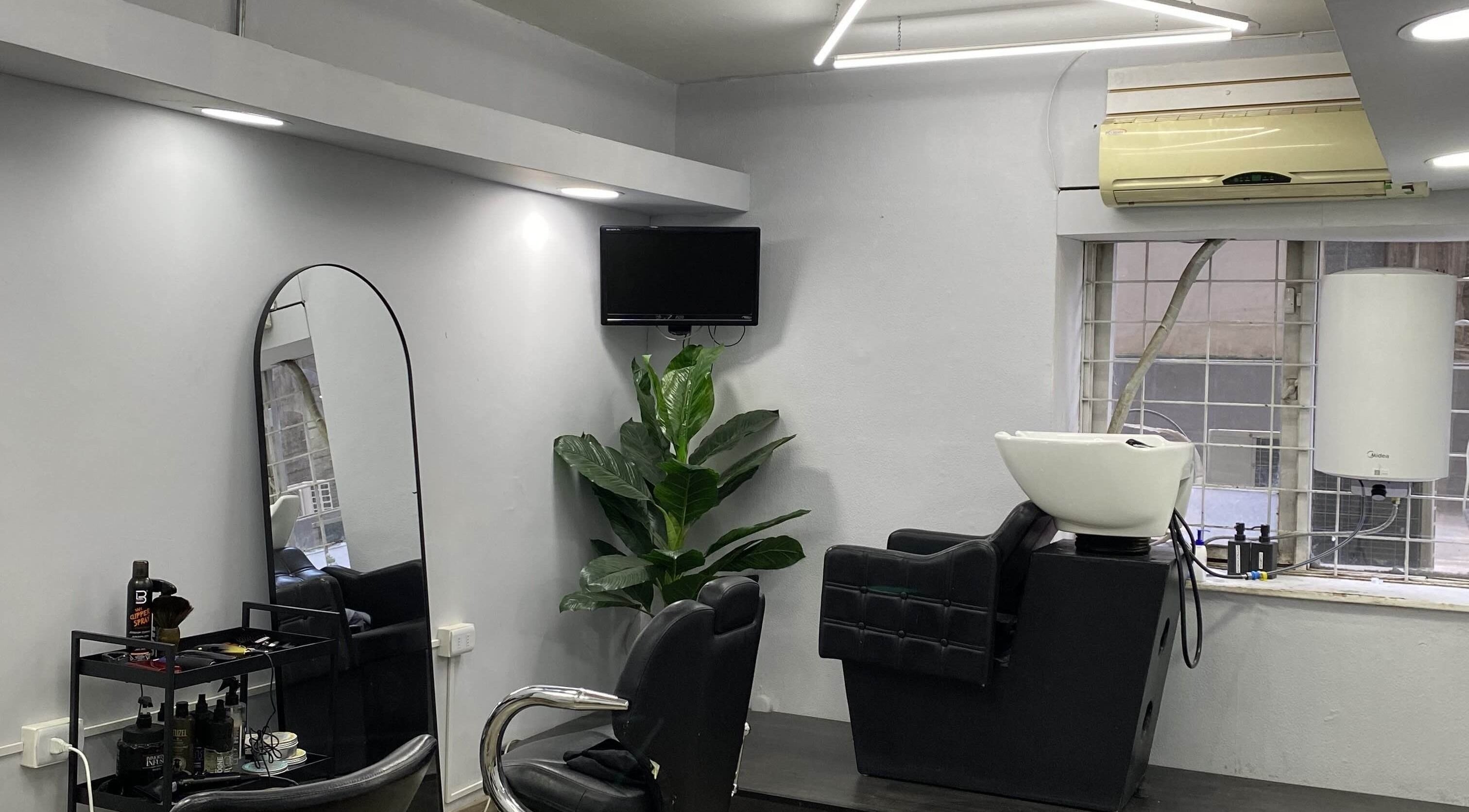 Interiores modernos de Centrvl Salon en Santiago, Región Metropolitana, CL, con estación de lavado y espejo elegante.