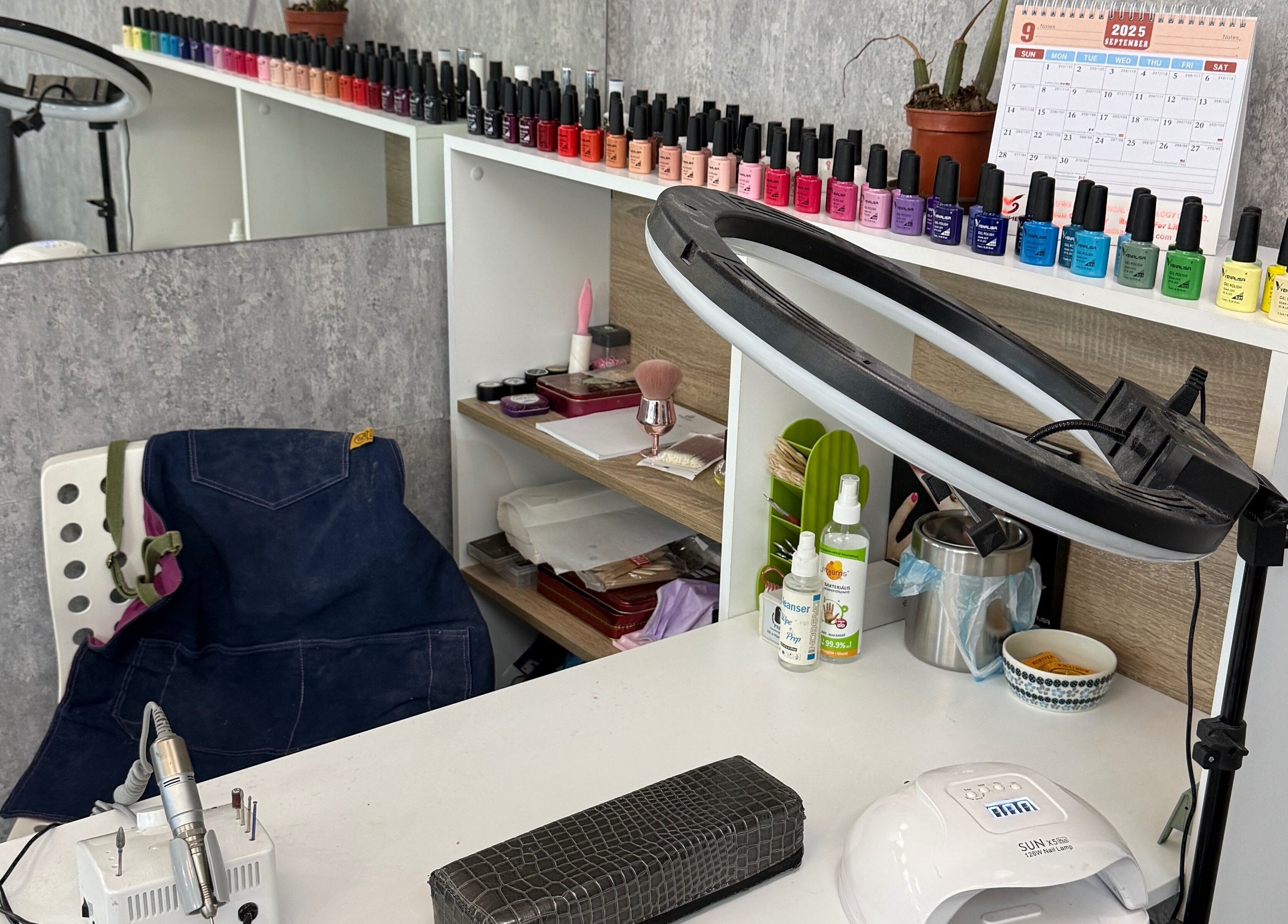 Nail polish station at Arya Beauty Salon, Budapest, Magyar, HU, featuring colorful polish and tools.