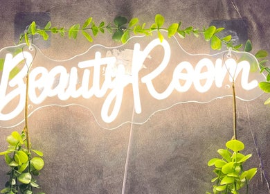 Illuminated 'Beauty Room' sign with greenery at LadamsNails, Ottawa, Ontario, CA.