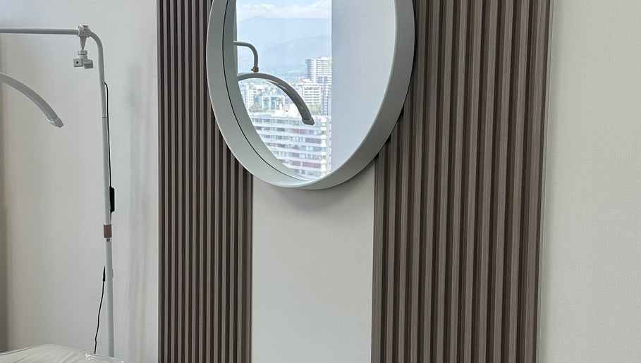 Elegante espejo redondo en Luxury Lashes, Ñuñoa, Región Metropolitana, CL, refleja el paisaje urbano.