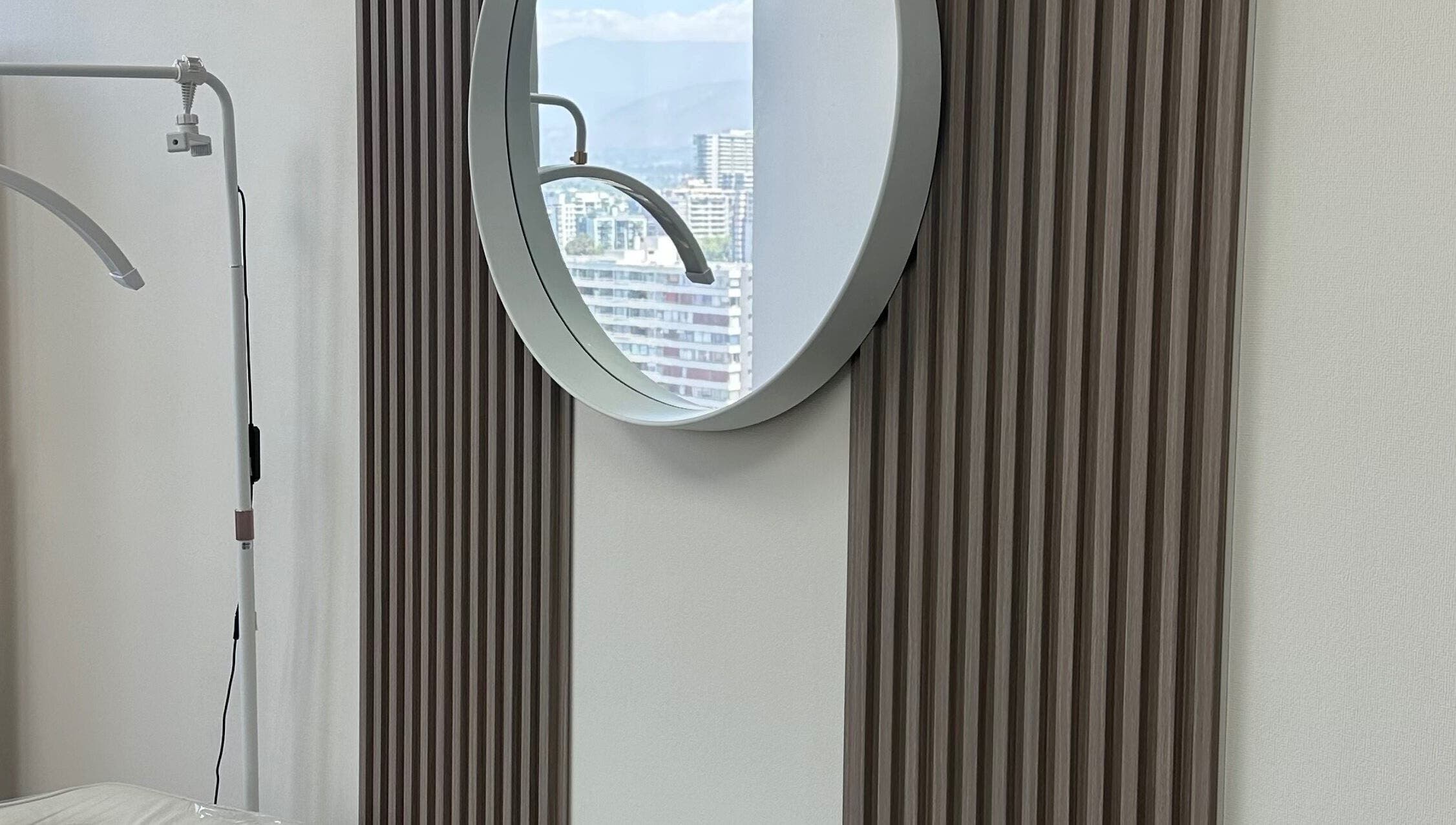 Elegante espejo redondo en Luxury Lashes, Ñuñoa, Región Metropolitana, CL, refleja el paisaje urbano.