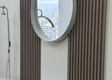 Elegante espejo redondo en Luxury Lashes, Ñuñoa, Región Metropolitana, CL, refleja el paisaje urbano.