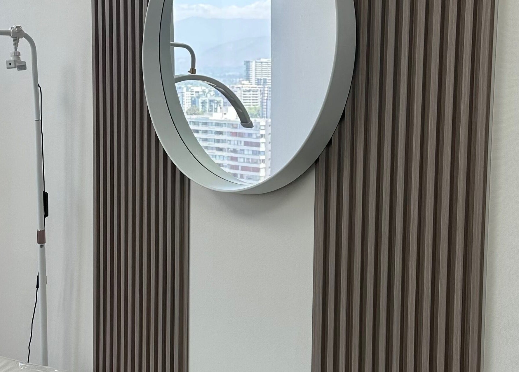 Elegante espejo redondo en Luxury Lashes, Ñuñoa, Región Metropolitana, CL, refleja el paisaje urbano.