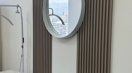 Elegante espejo redondo en Luxury Lashes, Ñuñoa, Región Metropolitana, CL, refleja el paisaje urbano.