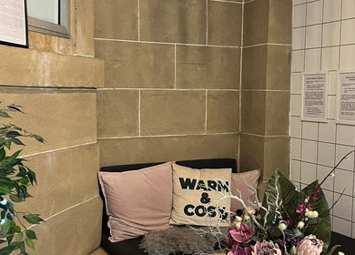 Relaxing nook at Bonnie Belle Nails, Glasgow, Scotland, GB, featuring soft cushions and vibrant floral decor.