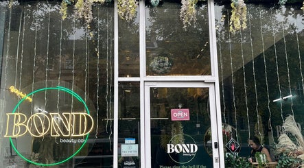Stylish entrance at Bonnie Belle Nails, Glasgow, Scotland, GB featuring vibrant signage and greenery.