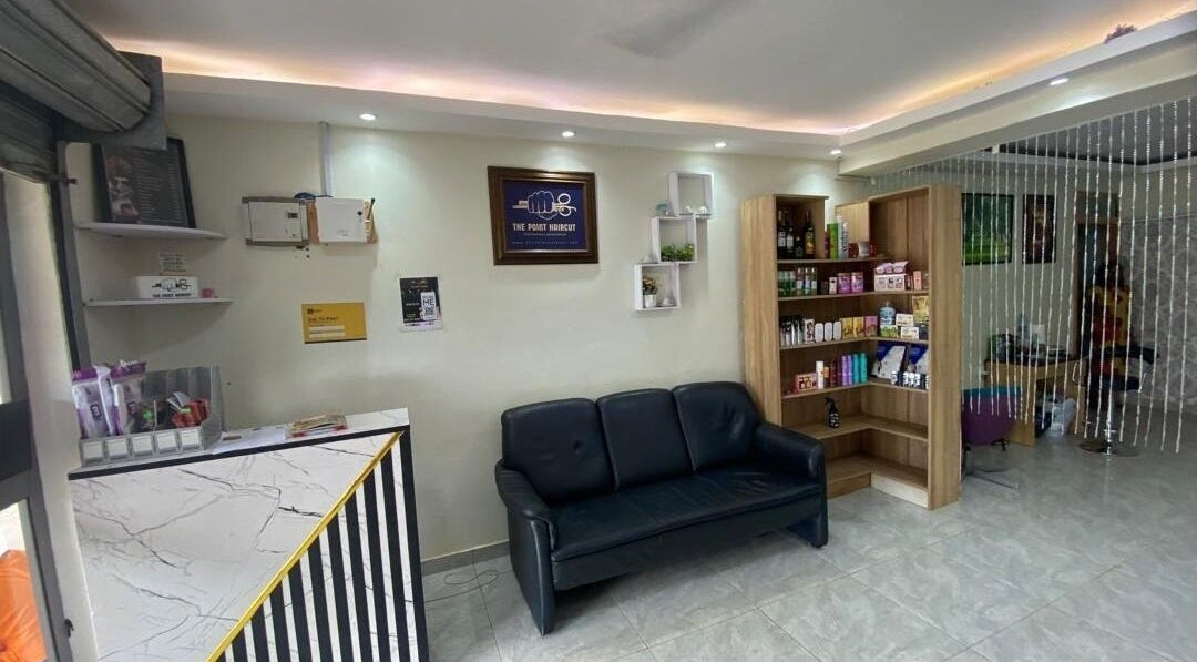 Reception area at The Point Haircut & Spa, Accra, showcasing a stylish waiting area and product display.