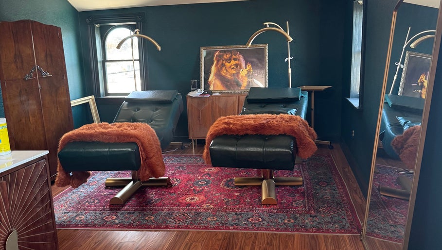 Luxury treatment room at Electric Beauty Co, Alameda, California, US with plush chairs and artistic decor.