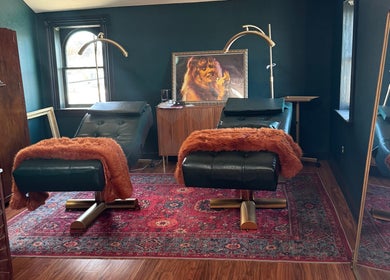 Luxury treatment room at Electric Beauty Co, Alameda, California, US with plush chairs and artistic decor.