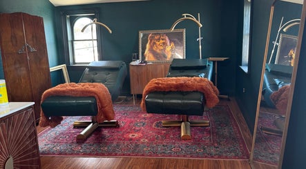 Luxury treatment room at Electric Beauty Co, Alameda, California, US with plush chairs and artistic decor.