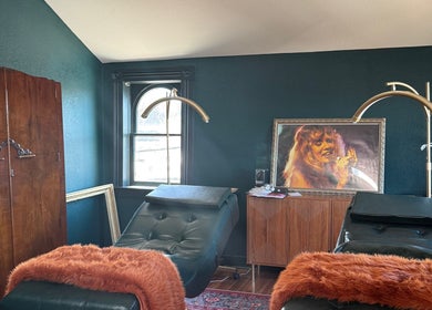 Elegant treatment room at Electric Beauty Co in Alameda, California, US with plush chairs and warm decor.