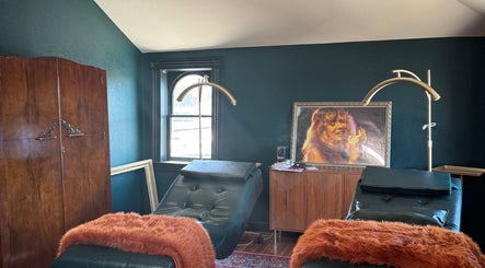 Elegant treatment room at Electric Beauty Co in Alameda, California, US with plush chairs and warm decor.