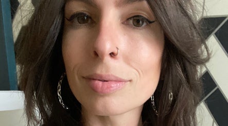 Close-up of a woman with bold eyeliner and hoop earrings at Electric Beauty Co, Alameda, California, US.