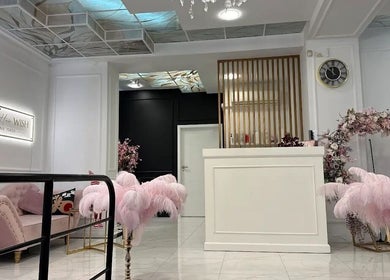 Eleganckie wnętrze Beauty Code w Szczecin, Województwo Zachodniopomorskie z różową sofą i wystrojem.