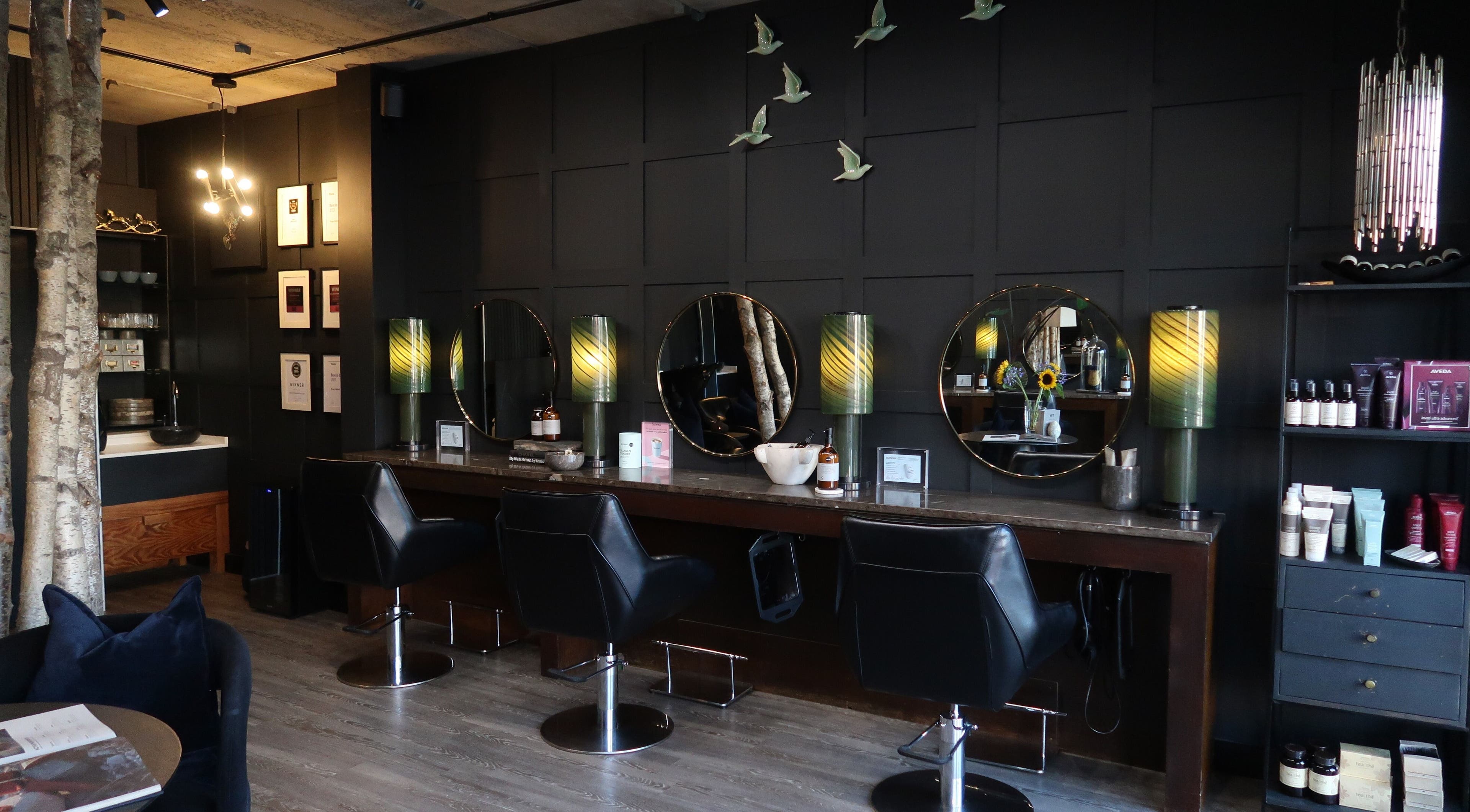 Elegant salon setup at Tracy Walker, Arundel, England, GB with modern lighting and styling stations.