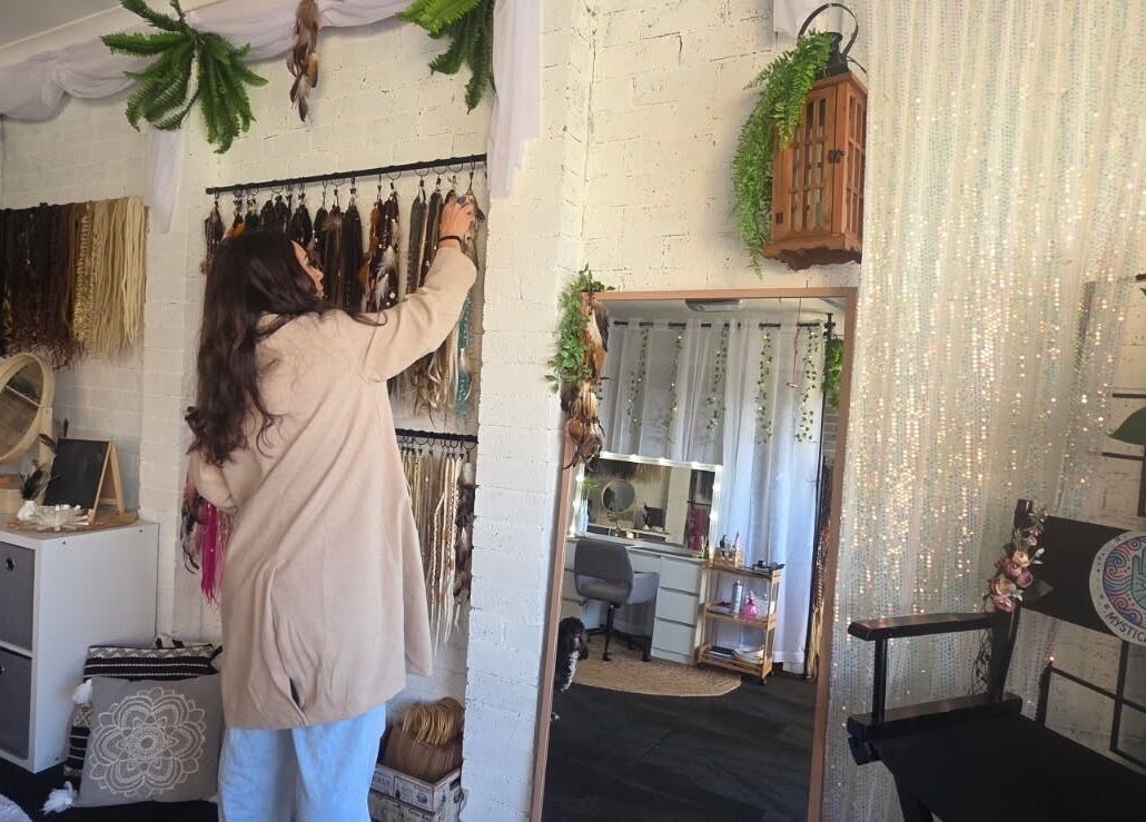 A woman arranges bohemian decor at Mystical Masks ✨, Mornington, Vic, AU, reflecting a serene, stylish space.