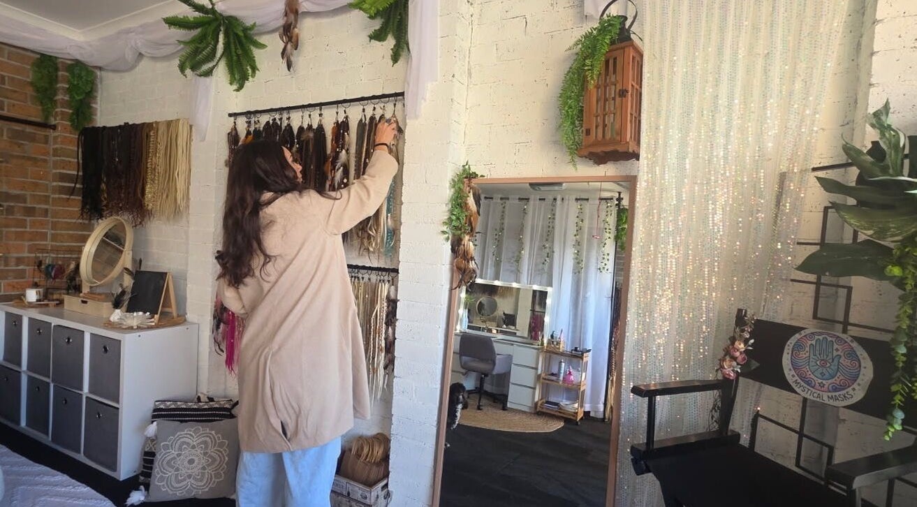 A woman arranges bohemian decor at Mystical Masks ✨, Mornington, Vic, AU, reflecting a serene, stylish space.
