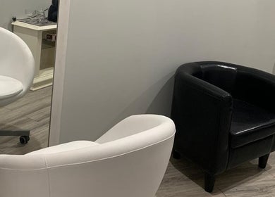 Espaço aconchegante no Lidiane Silva em Lourinhã, Lisboa, PT, com cadeiras branca e preta em destaque.