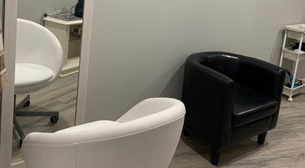 Espaço aconchegante no Lidiane Silva em Lourinhã, Lisboa, PT, com cadeiras branca e preta em destaque.