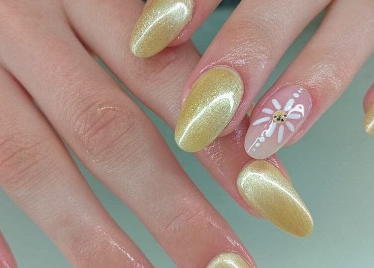 Stylish golden nails with floral design by Gizzelle B in Cape Town, Western Cape, ZA.