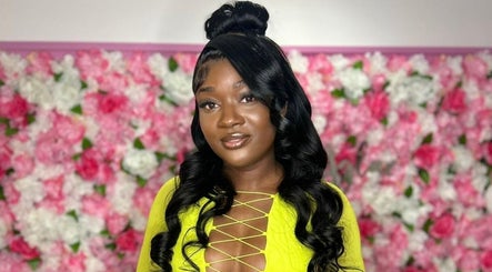 Client satisfaite chez Beauté Aglaë à Montréal, Québec, CA devant un mur floral vibrant.