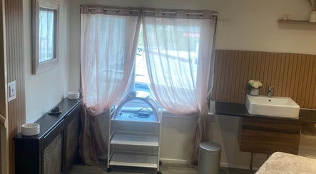 Cozy treatment room at Anaya Beauty in Inverness, Scotland, GB with soft pink curtains and modern decor.