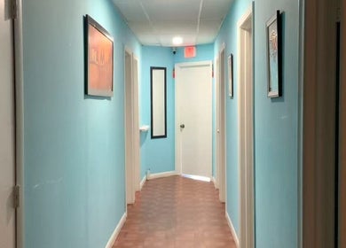 Calm hallway at Wellness Foot Spa in Glenside, Pennsylvania, US with soft blue walls leading to treatment rooms.