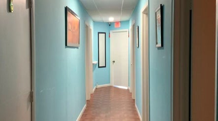 Calm hallway at Wellness Foot Spa in Glenside, Pennsylvania, US with soft blue walls leading to treatment rooms.