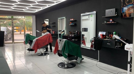 Interior moderno de barbería en Cancún, Quintana Roo, MX, cliente recibiendo corte de cabello profesional.