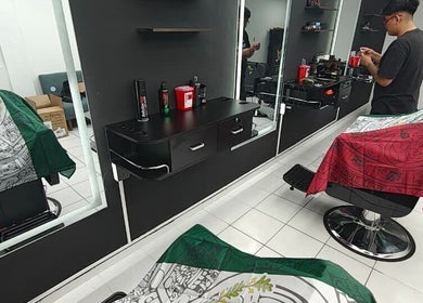 Interior moderno de Barberia en Cancún, Quintana Roo, MX, mostrando sillas y estantes elegantes.