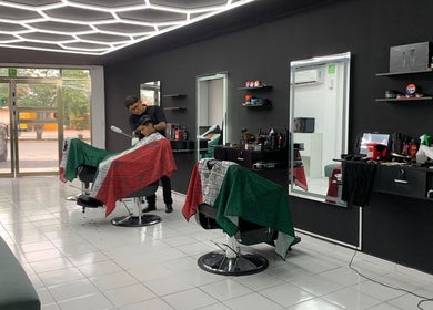 Interior moderno de barbería en Cancún, Quintana Roo, MX con cliente recibiendo corte.