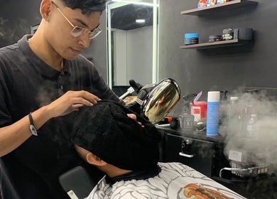 Tratamiento facial en barberia en Cancún, Quintana Roo, MX, usando vapor para cuidado de piel.