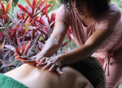 Relaxing massage session at Meraki massage by Haidelyn Cordoba in Frome, GB with lush plant backdrop.