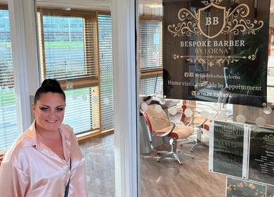 Woman smiling at Bespoke Barber by Lorna entrance in Wythenshawe, England, GB.