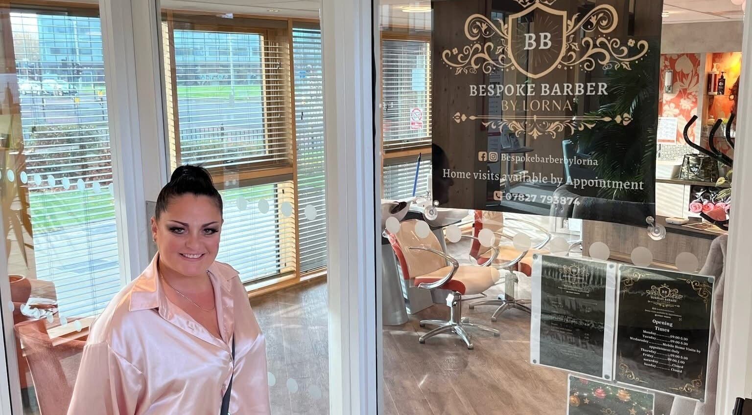 Woman smiling at Bespoke Barber by Lorna entrance in Wythenshawe, England, GB.