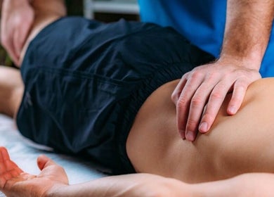 Massage therapy session at Mobility and Massage, Huddersfield, England, GB showing hands applying pressure on a back.