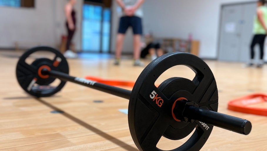 5kg barbell on floor at MK Training in Holyport, England, GB with blurred fitness background.