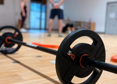 5kg barbell on floor at MK Training in Holyport, England, GB with blurred fitness background.