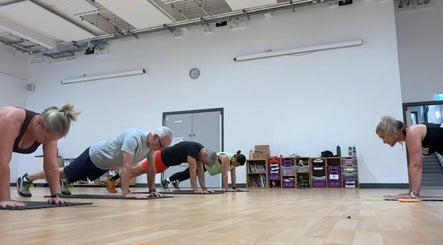 Group fitness session at MK Training in Holyport, England, GB, featuring participants in plank positions.