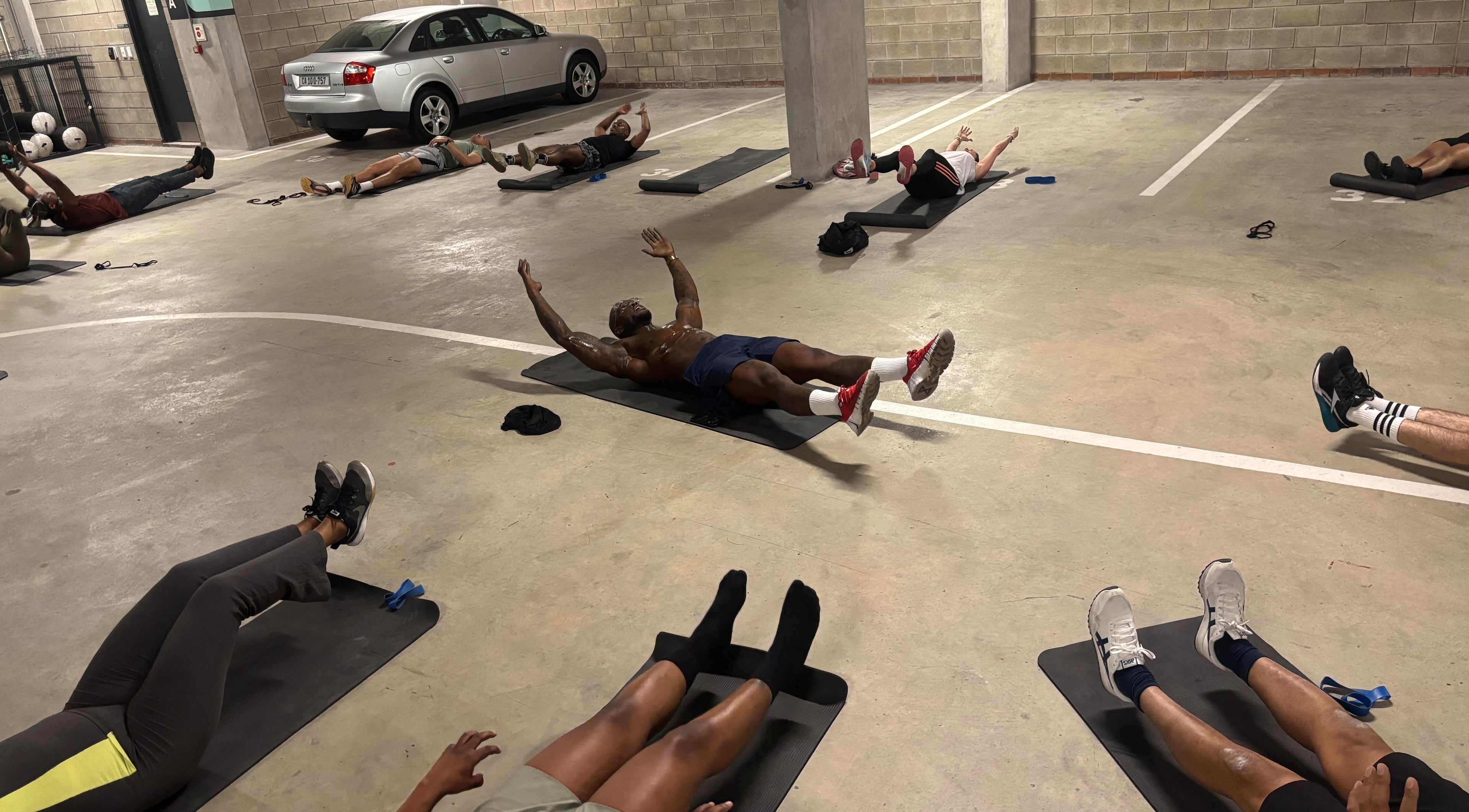 Fitness class at TREMBL, Cape Town, Western Cape, ZA with participants doing exercises on mats.
