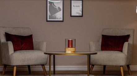 Elegant seating area at Skin & Glo, Macclesfield, England, GB featuring plush chairs and a stylish table.