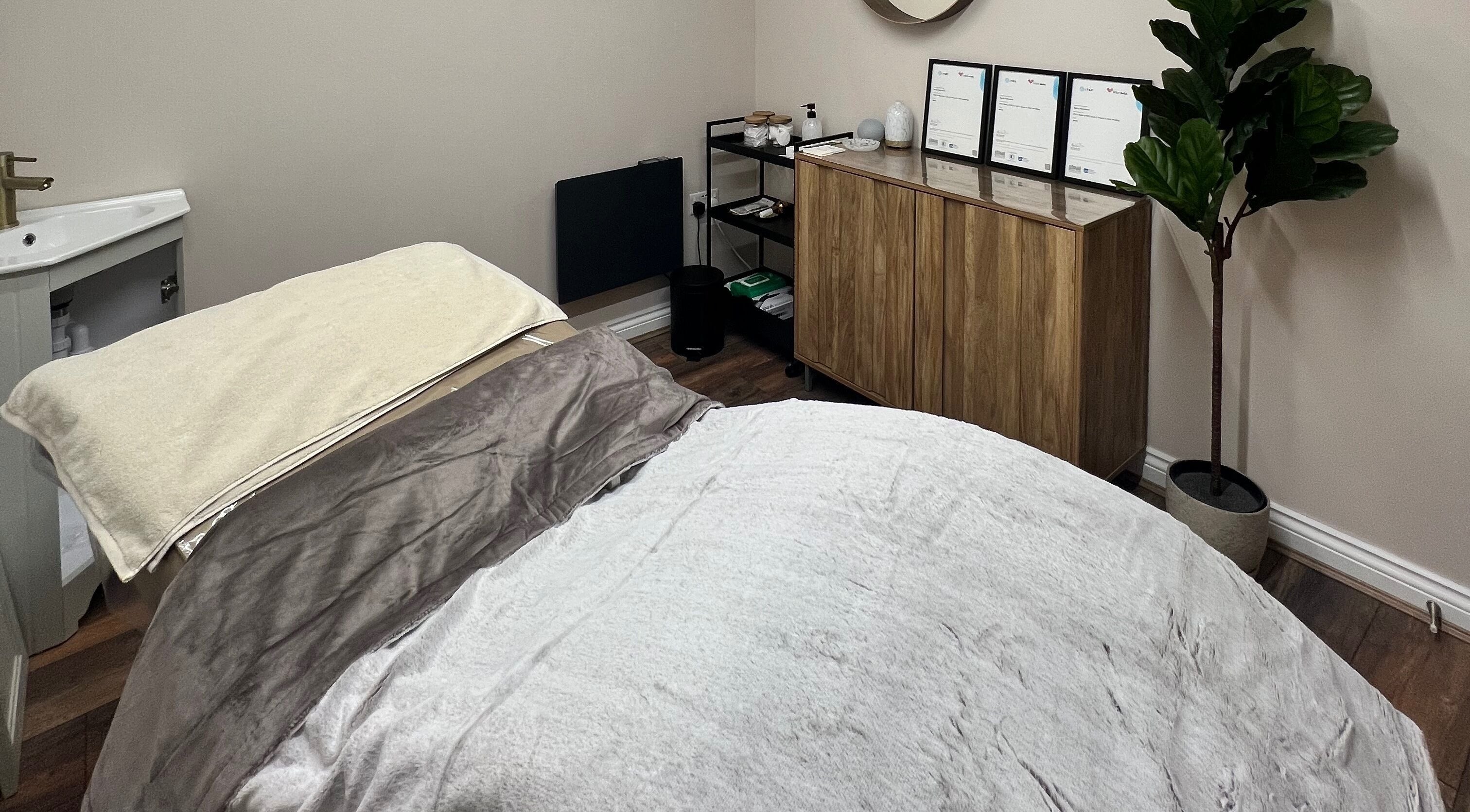 Cozy spa room at Skin & Glo in Macclesfield, England, GB with a massage table and soothing decor.