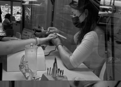Nail artist at MariLopes naildesign in Vila Nova De Famalicão, Braga, PT, carefully files client's nails.