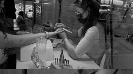 Nail artist at MariLopes naildesign in Vila Nova De Famalicão, Braga, PT, carefully files client's nails.