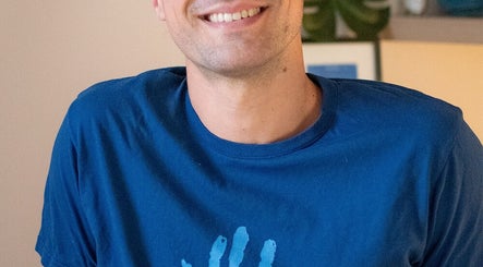 Homme souriant à Up2 Massages, Paris, Île-de-France, FR, créant une ambiance apaisante.