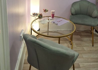 Cozy seating area at massage.facial.by.sasha.viki in Glasgow, Scotland, GB. Elegant chairs and a glass table.