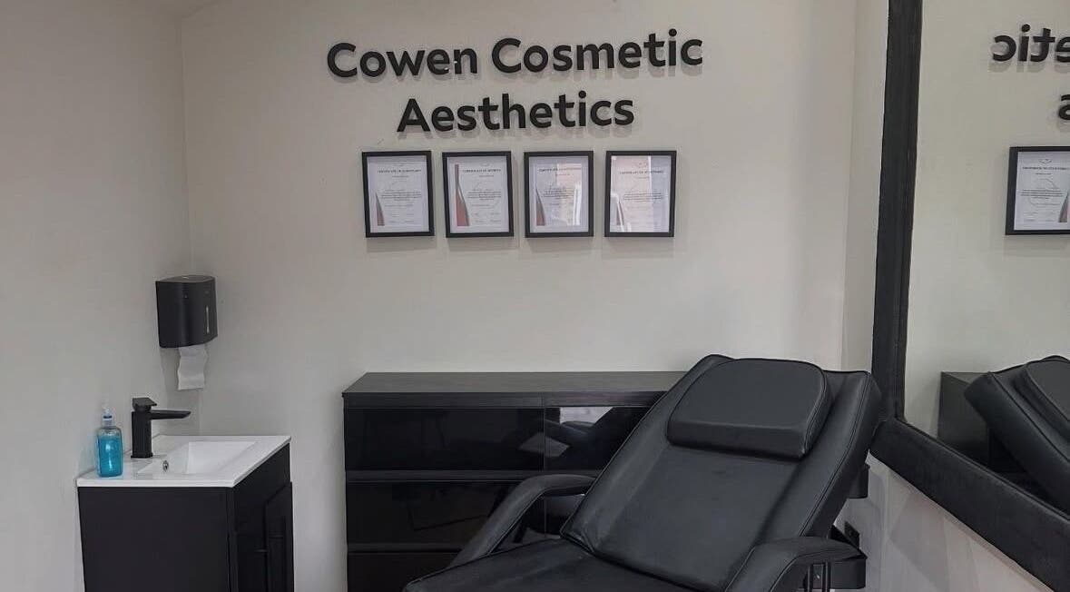 Cowen Cosmetic Aesthetics in Hoghton, England, GB. Modern treatment room with certificates and sleek black seating.